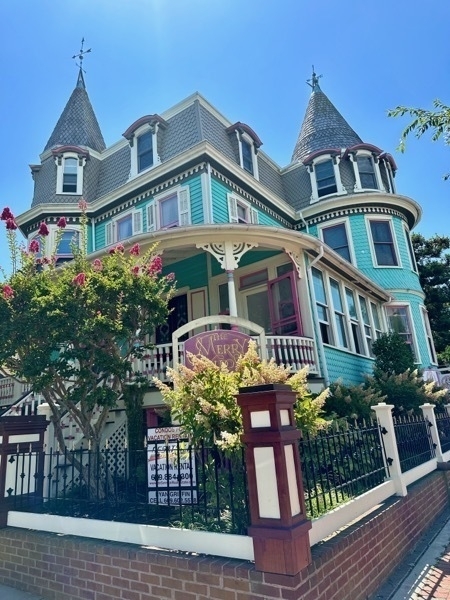 Photo of a victorian mansion painted teal and pink.