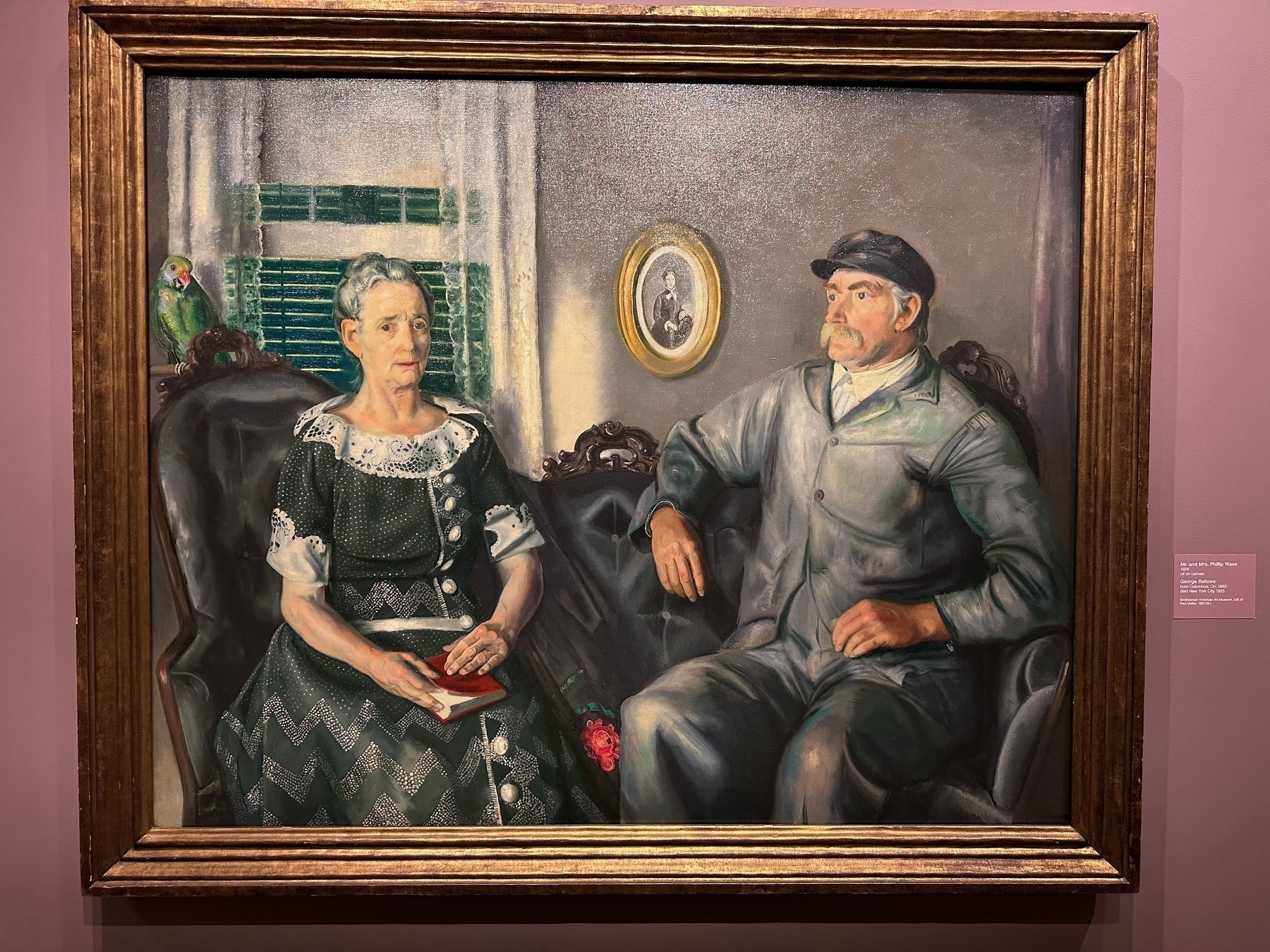 Painting of an elderly man and woman sitting in their parlour.