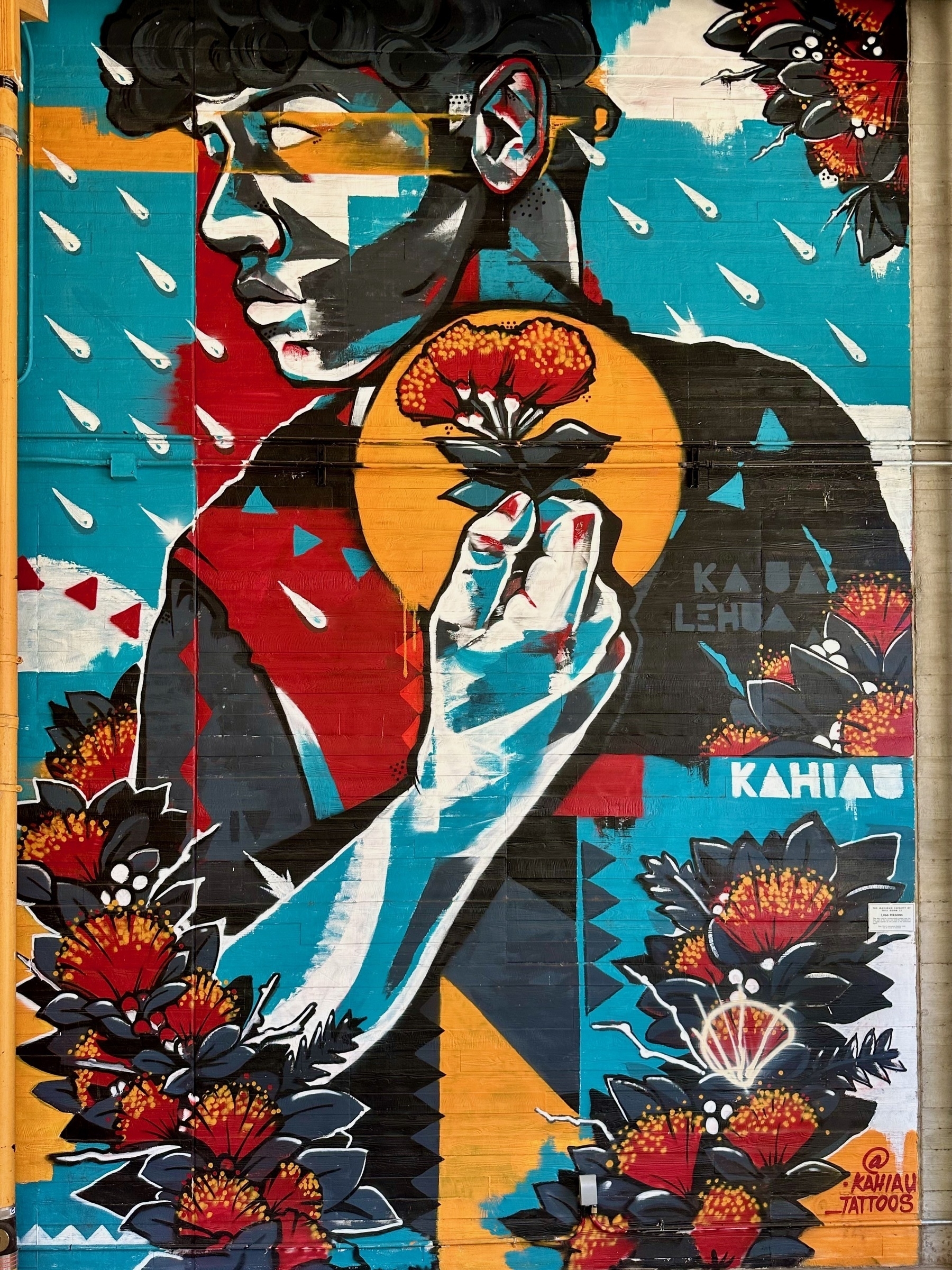 Mural of a young man holding a flower, facing falling raindrops. Made by @kahiau_tattoos.