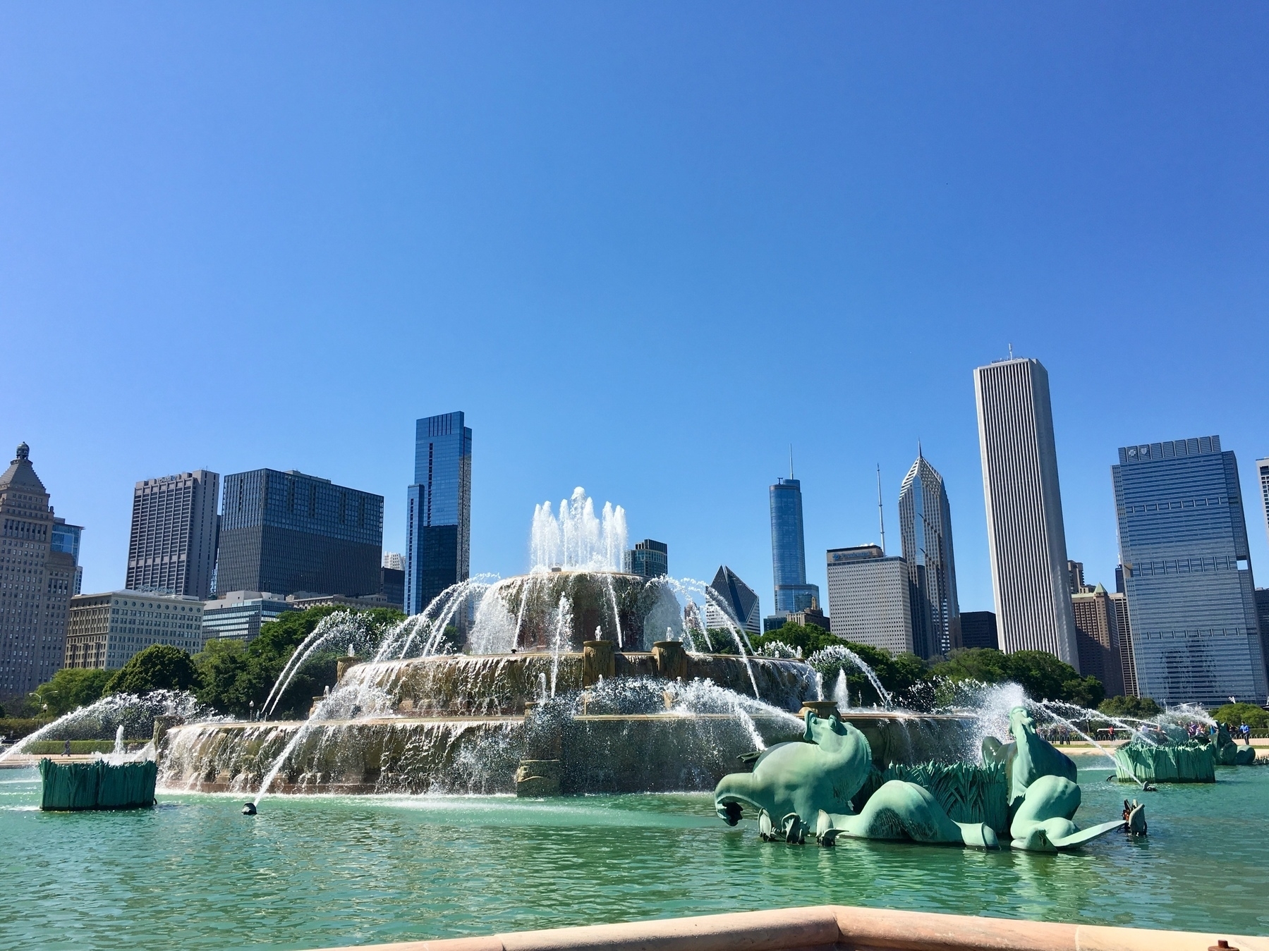 Buckingham fountain and Chicago skyline under a clear, cloudless blue sky.